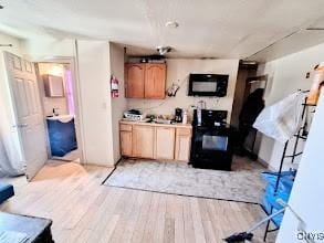 kitchen featuring stove, light brown cabinetry, and light hardwood / wood-style flooring