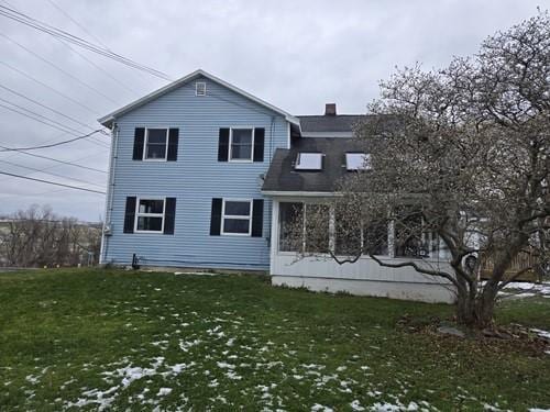 rear view of house featuring a lawn