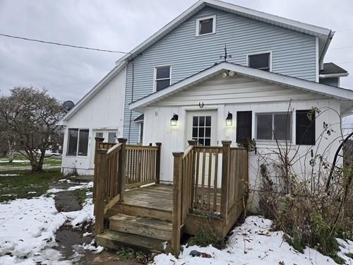 view of snow covered rear of property