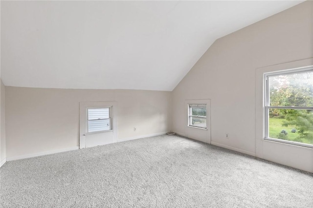 bonus room with carpet flooring, a healthy amount of sunlight, and vaulted ceiling