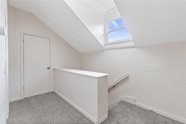 additional living space featuring light carpet and vaulted ceiling