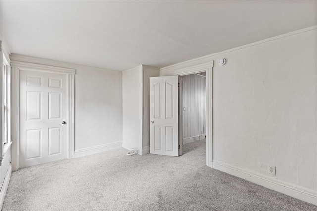 spare room with crown molding and light carpet