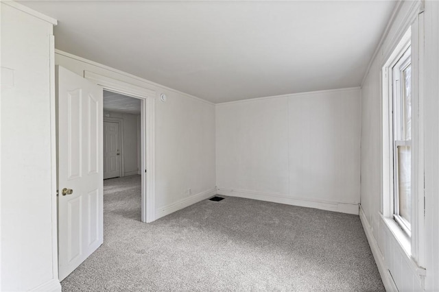 spare room with a wealth of natural light and light carpet