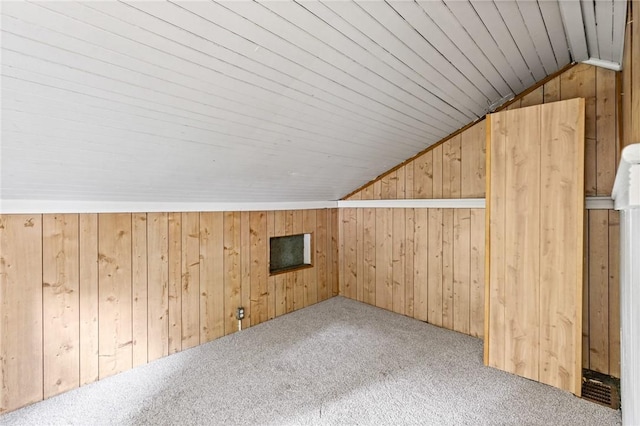 additional living space with carpet, wood ceiling, lofted ceiling, and wood walls