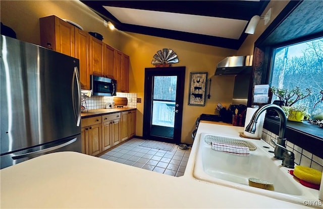 kitchen with light tile patterned flooring, appliances with stainless steel finishes, backsplash, and sink