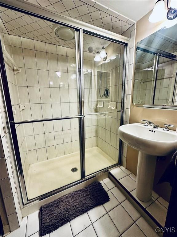 bathroom featuring tile patterned floors and a shower with shower door