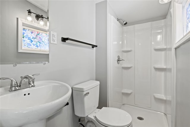 bathroom with a shower, toilet, and sink