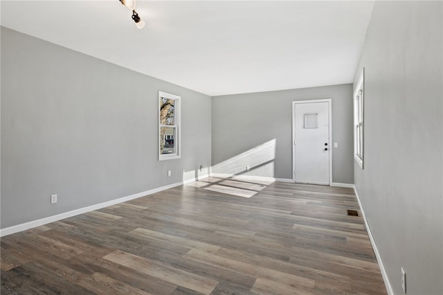 empty room featuring plenty of natural light and hardwood / wood-style flooring