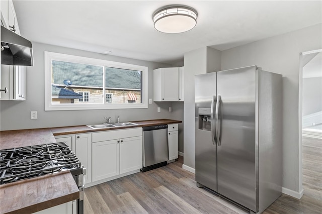 kitchen featuring wood counters, sink, white cabinets, and appliances with stainless steel finishes