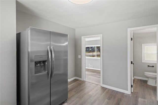 kitchen with stainless steel refrigerator with ice dispenser and light hardwood / wood-style floors