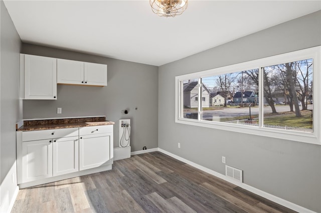 laundry room featuring cabinets, washer hookup, dark hardwood / wood-style floors, and electric dryer hookup