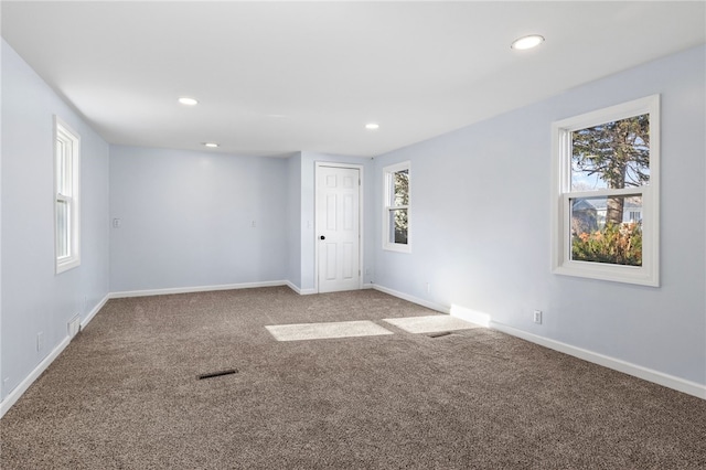 carpeted empty room featuring a wealth of natural light