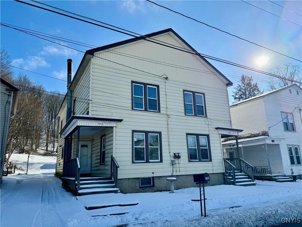 view of snow covered back of property