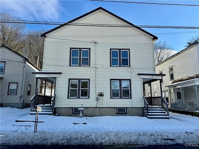 view of snow covered rear of property