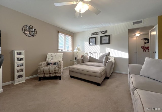 carpeted living room with ceiling fan