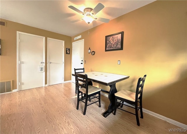 dining room with ceiling fan and light wood-type flooring