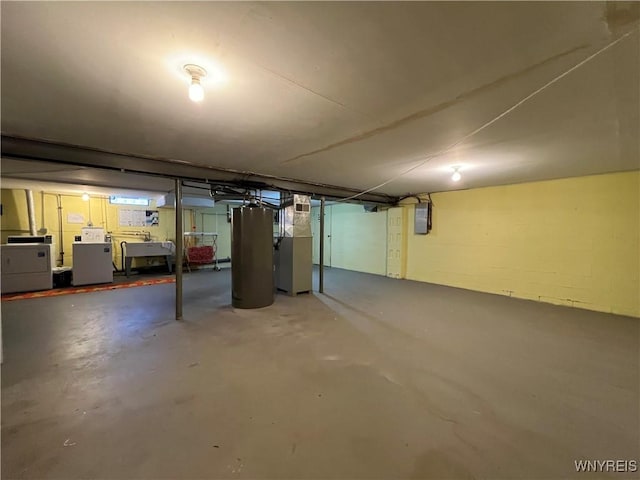 basement featuring electric panel, sink, washer and dryer, water heater, and heating unit