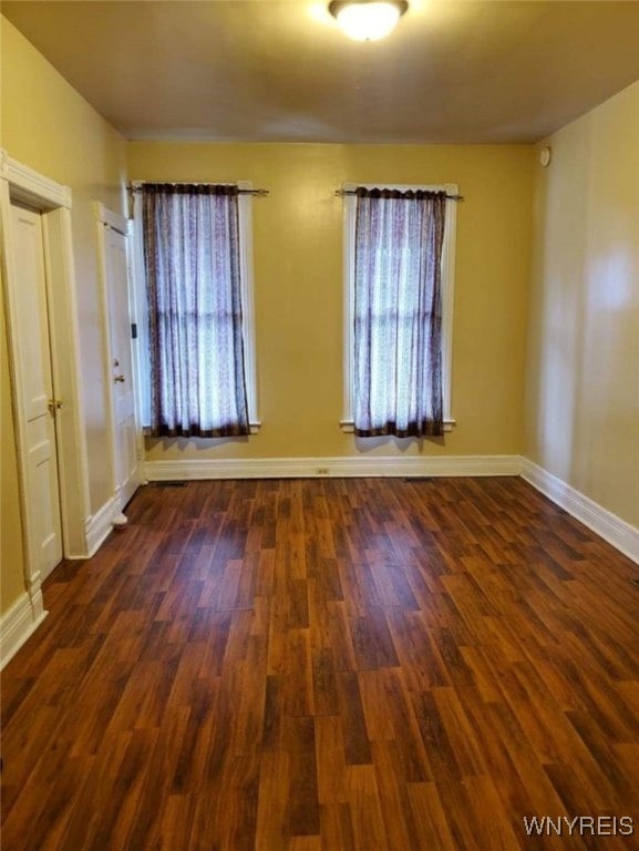 unfurnished room featuring dark wood-type flooring