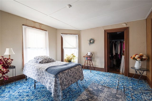 carpeted bedroom featuring a spacious closet and a closet