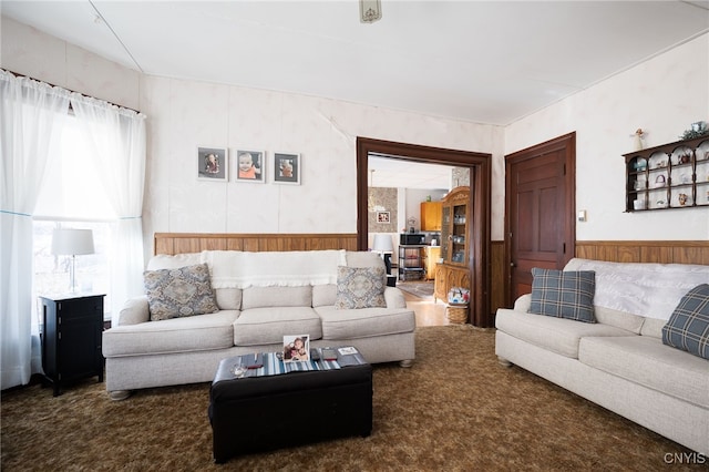 carpeted living room with wood walls