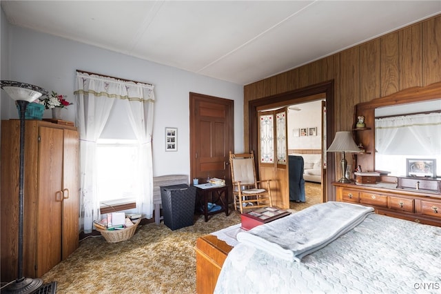 bedroom with carpet and wooden walls