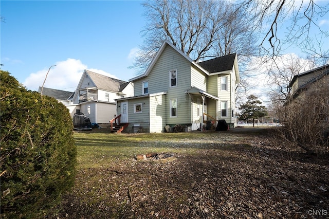 rear view of house with a yard and a trampoline