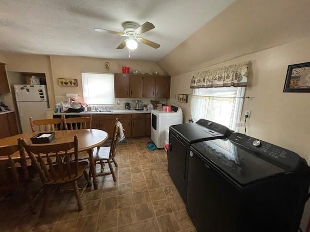 kitchen featuring ceiling fan, white refrigerator, lofted ceiling, and washing machine and clothes dryer