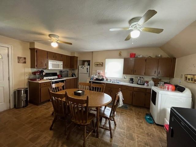 kitchen featuring lofted ceiling, ceiling fan, white appliances, and independent washer and dryer