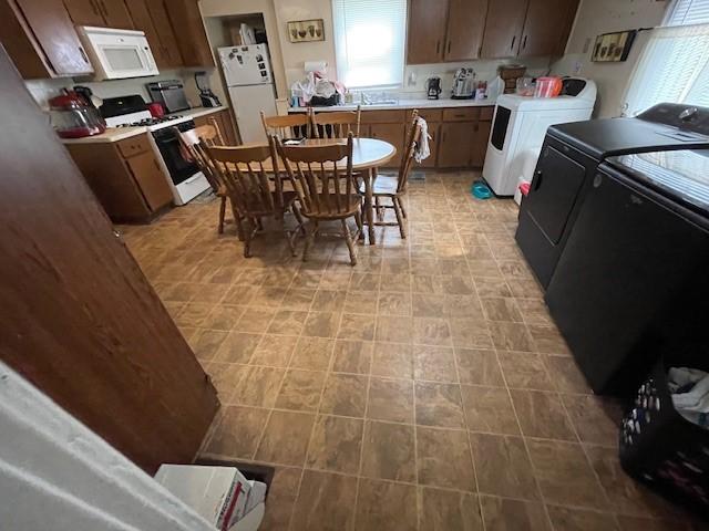 kitchen featuring independent washer and dryer and white appliances