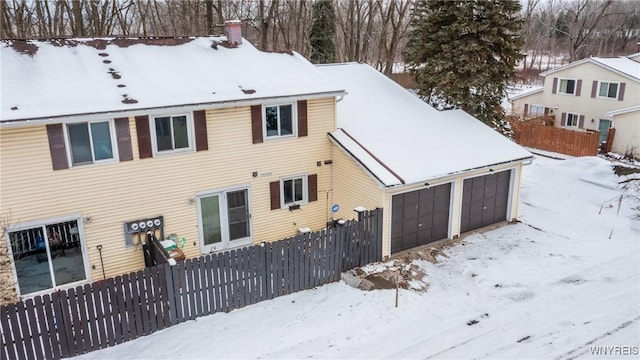 snow covered house with a garage