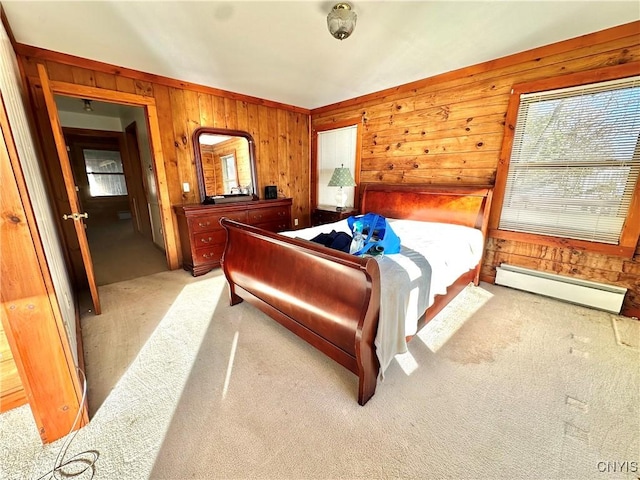 bedroom featuring wood walls, light carpet, and a baseboard heating unit