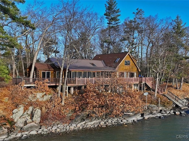 rear view of property featuring a deck with water view