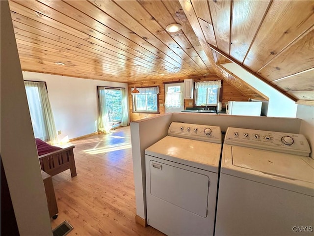 laundry room with washer and dryer, wood ceiling, and light wood-type flooring