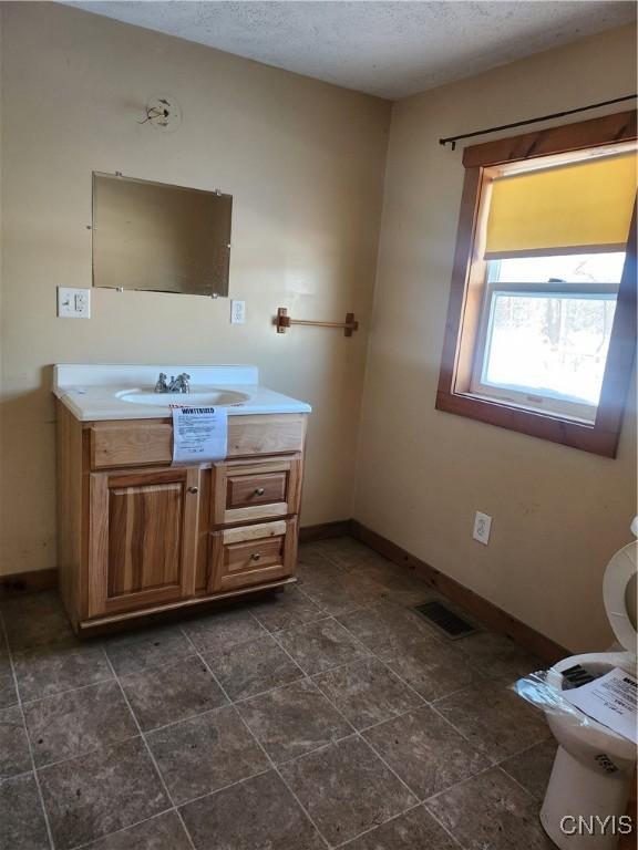 bathroom featuring vanity, toilet, and a textured ceiling