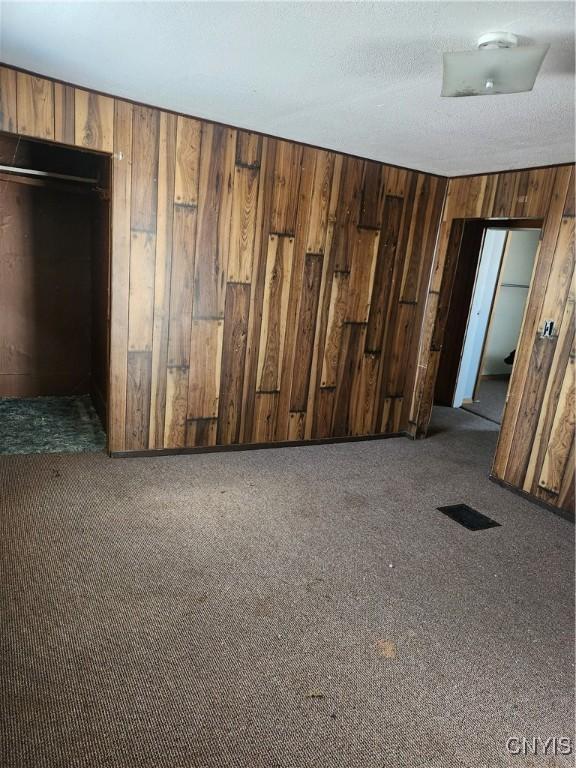 4057 Wilson Rd E, Annsville, NY 13471 - unfurnished room featuring wooden walls and carpet