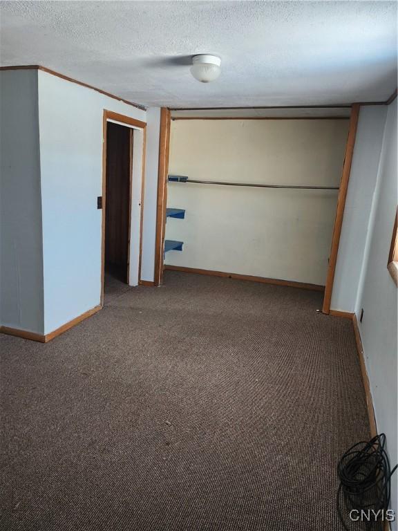 carpeted empty room with a textured ceiling