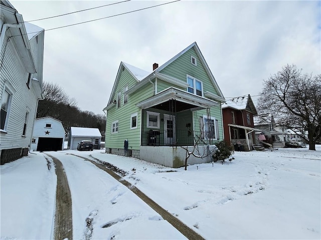 view of front of home with covered porch, a garage, and an outdoor structure