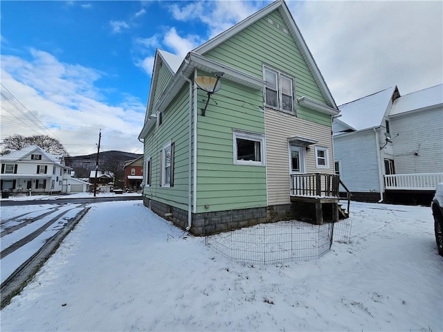 view of snow covered back of property