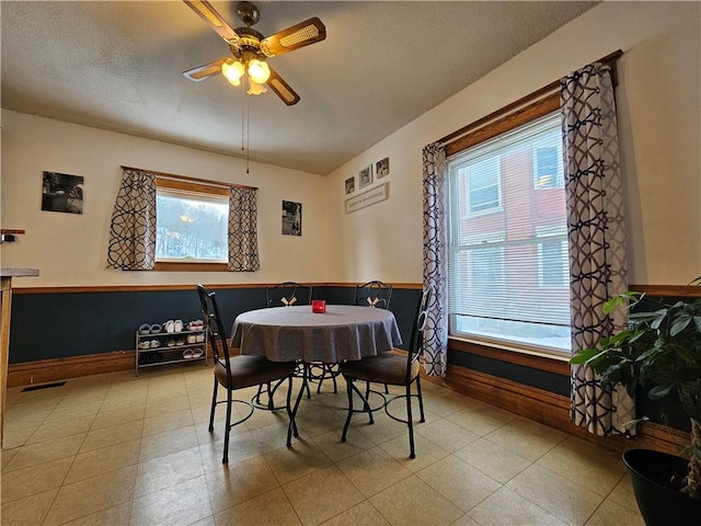 dining room featuring a textured ceiling, ceiling fan, and a healthy amount of sunlight