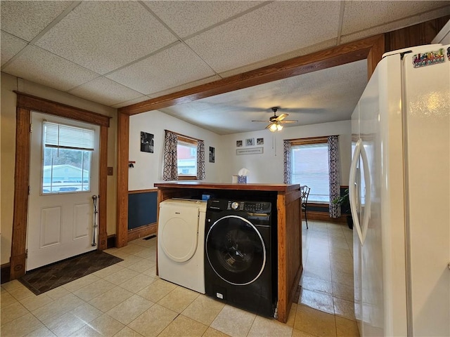 laundry area featuring a wealth of natural light, ceiling fan, and washing machine and clothes dryer