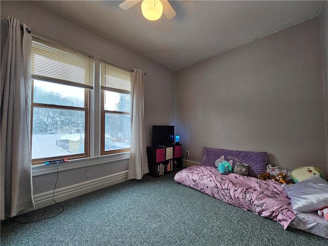 bedroom featuring ceiling fan, carpet floors, and a textured ceiling