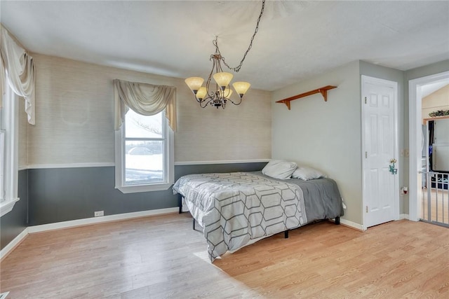 bedroom with light hardwood / wood-style flooring and an inviting chandelier