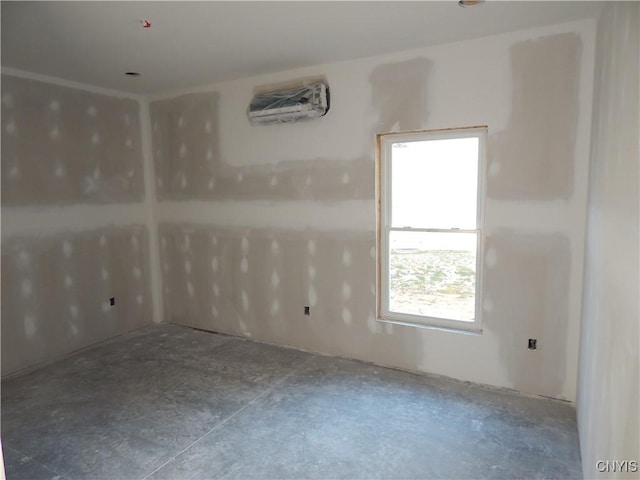 empty room featuring concrete flooring and an AC wall unit