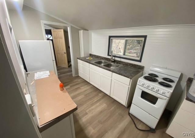 kitchen featuring sink, lofted ceiling, white appliances, white cabinets, and hardwood / wood-style flooring