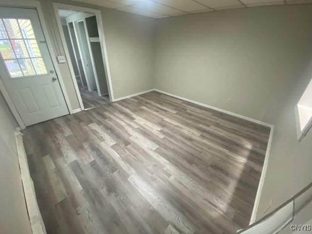 empty room featuring a drop ceiling and hardwood / wood-style floors