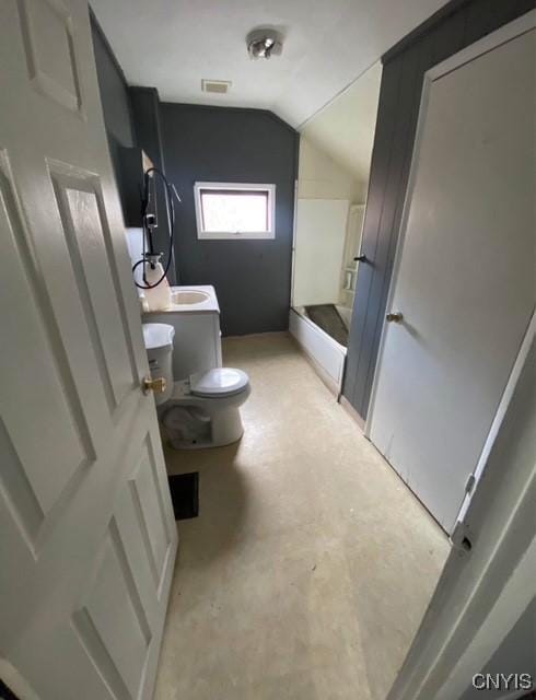 bathroom featuring vanity, vaulted ceiling, and toilet