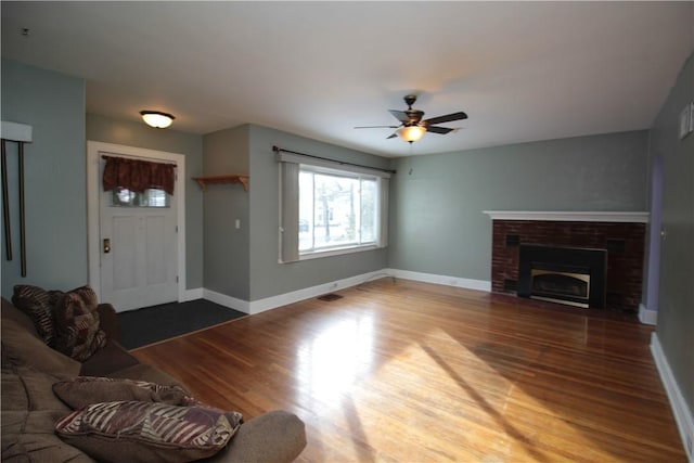 unfurnished living room with hardwood / wood-style floors, ceiling fan, and a fireplace