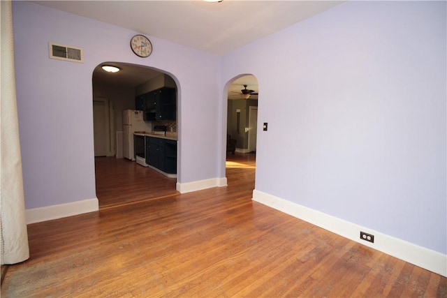 empty room with ceiling fan and wood-type flooring