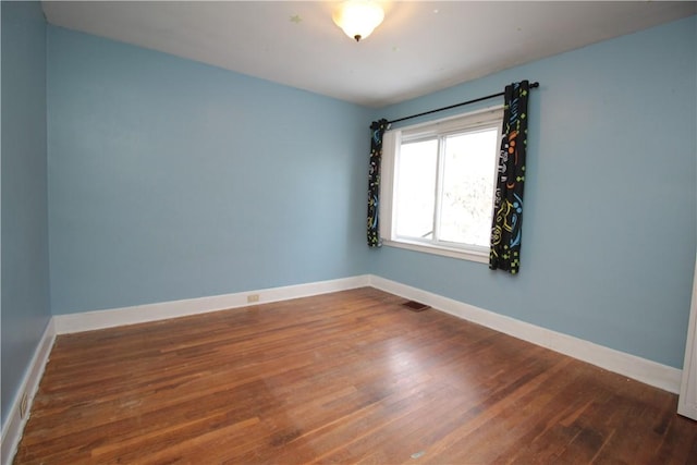 unfurnished room with dark wood-type flooring