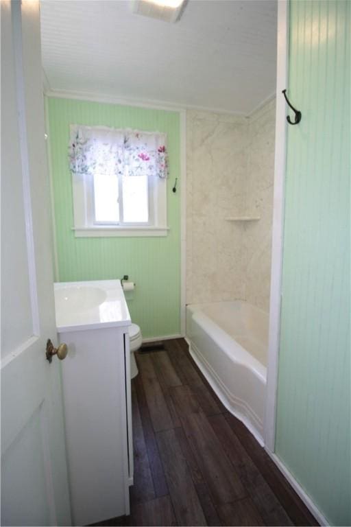 full bathroom featuring hardwood / wood-style floors, vanity, toilet, and tiled shower / bath